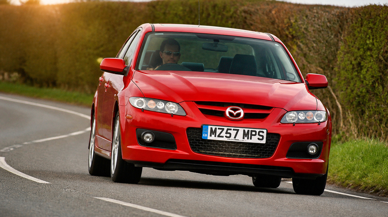 Carro esportivo vermelho Mazda em estrada curvada com motorista usando óculos escuros.