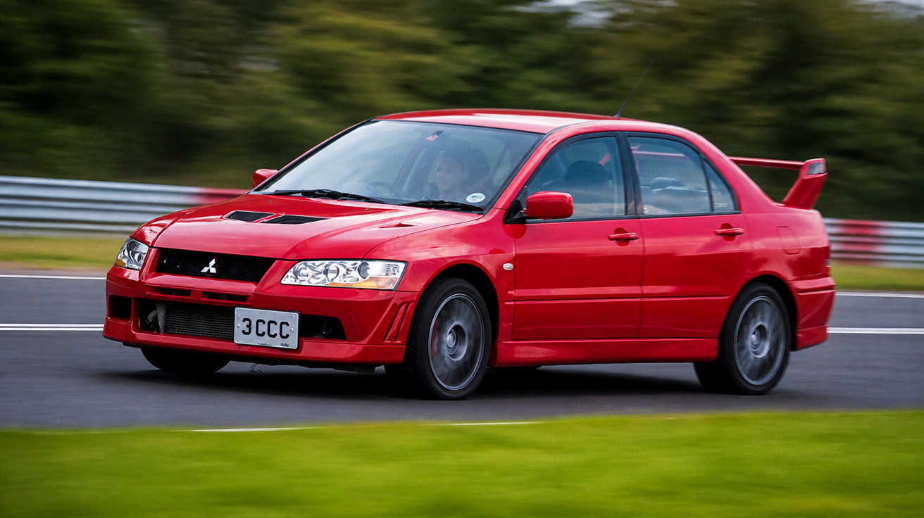 Carro esportivo vermelho Mitsubishi Lancer Evo em alta velocidade em pista de corrida.